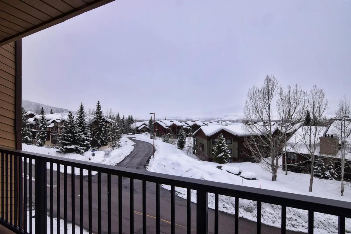 A tranquil winter landscape featuring snow-covered trees, a winding road, and a backdrop of mountains. The view is serene, suggesting opportunities for skiing, snowboarding, and winter walks in the surrounding area, while also highlighting the proximity to nature from the property.